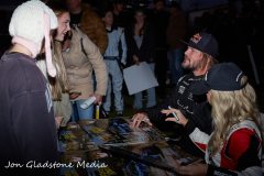 Toby Price and Holly Kilbride signing images for fans and drivers.